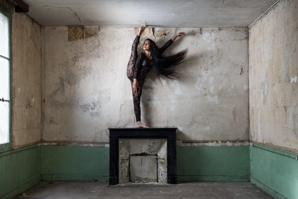 La danseuse fait le pied en l'air sur une cheminée en urbex pour le photographe Julien Benhamou.