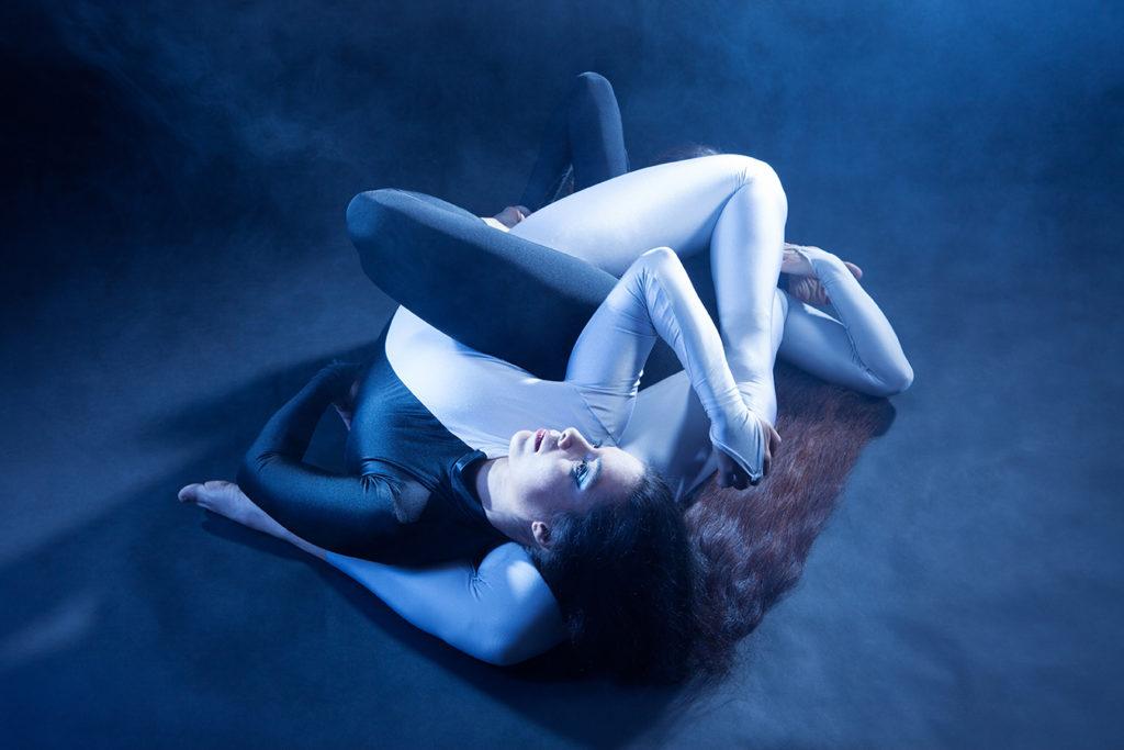 Deux contorsionniste emmêlées posent en forme de sculpture contemporaine pour une photographie de May Rohrer.