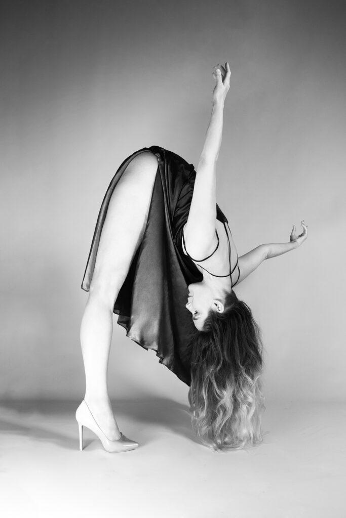 Une danseuse se penche en robe sur des talons.