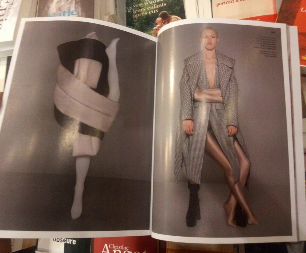 Une contorsionniste enlace un mannequin pour créer un effet graphique sur une photo dans un magazine de mode.